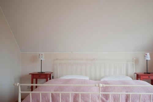 a bedroom with a white bed with two red tables at Ferienhausquartier Huberhof in Seehausen