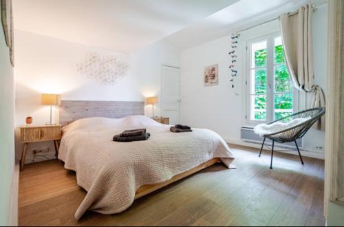 une chambre blanche avec un lit et une chaise dans l'établissement Aix-en-Provence : appartement de charme centre ville, à Aix-en-Provence