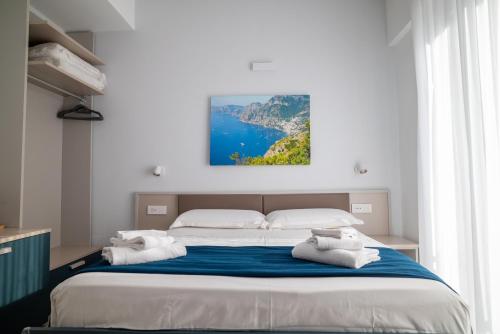 a bedroom with a large bed with towels on it at Divina Holiday - Rooms in Maiori