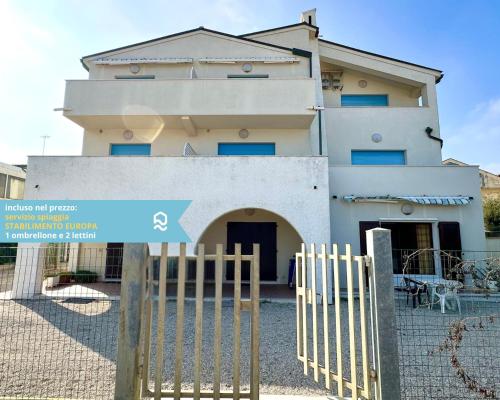 een gebouw met een blauw bord voor een hek bij RS317 - Marcelli, bilocale in residence fronte mare in Marcelli