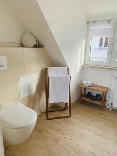 a white bathroom with a toilet and a window at Stuv Mariken - Apartment in Warnemünde in Rostock
