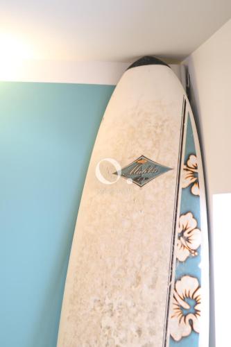 une planche de surf dans un coin d'une pièce avec une planche de surf dans l'établissement COC - Bleu d'Opale, à Wissant