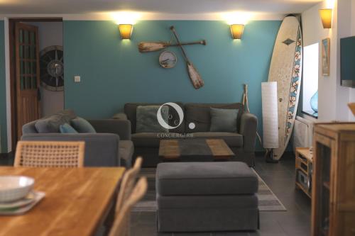 a living room with a couch and a surfboard on the wall at COC - Bleu d'Opale in Wissant