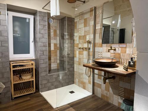 a bathroom with a sink and a glass shower at La Casupola by MONHOLIDAY in Monopoli
