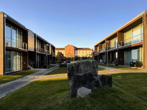 a large rock sitting in the grass in front of buildings at Gelfa SEAcrets in Caminha