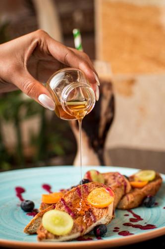 a person holding a glass of wine over a plate of food at Mantra Hotel Boutique in Santa Marta