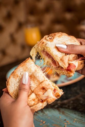 a person holding a sandwich on a plate at Mantra Hotel Boutique in Santa Marta