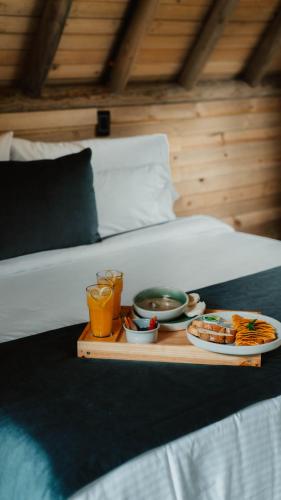 a tray with food and drinks on a bed at EcoHotel Cantos del Rio in Cajamarca