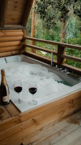 two glasses of wine on a hot tub with snow at EcoHotel Cantos del Rio in Cajamarca
