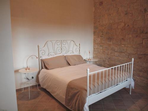 a bedroom with a white bed and two tables at Agriturismo Arà in Casale Zappulla