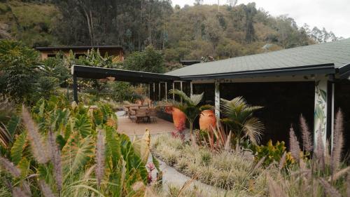 a house with a patio with plants in front of it at EcoHotel Cantos del Rio in Cajamarca