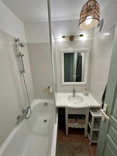 une salle de bain blanche avec un lavabo et une douche dans l'établissement La Madrague, aux Issambres