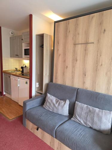 - un canapé bleu dans un salon avec une cuisine dans l'établissement Appartement 2P Isola 2000, à Isola 2000