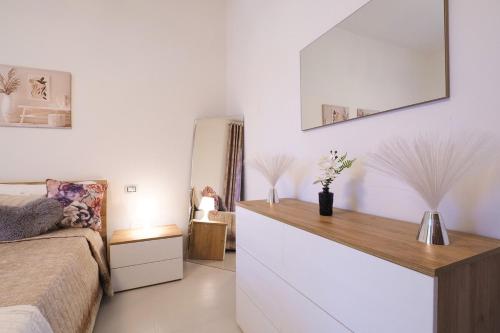 una camera da letto con un letto e uno specchio sul muro di Melody's Garden House a Como