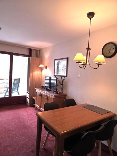 une salle à manger avec une table et une horloge au mur dans l'établissement Appartement 2P Isola 2000, à Isola 2000