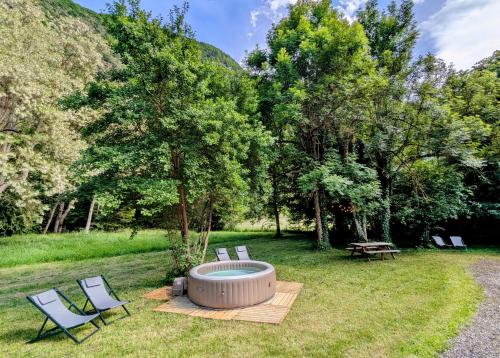 un groupe de chaises et un foyer extérieur dans l'herbe dans l'établissement Maison avec grand jardin, garage, jacuzzi supplément, au Bourg-dʼOisans