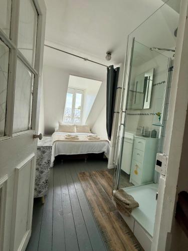une petite chambre avec un lit et un miroir dans l'établissement La Victoire, à Saint-Aubin-sur-Mer