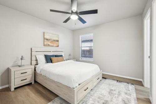 a white bedroom with a bed and a ceiling fan at The Chandler 1111 I Comfy 2 Bed 2 Bath in Grand Prairie