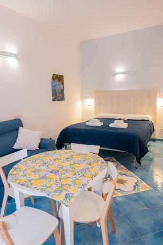 a room with a bed and a table and chairs at Divina Holiday - Apartments in Maiori