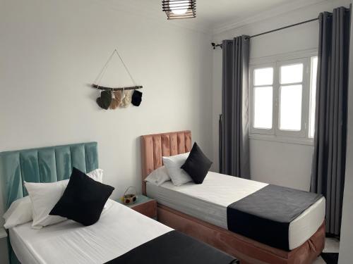 a bedroom with two beds and a window at Casa Marwan in Tetouan