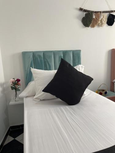 a bed with black and white pillows on it at Casa Marwan in Tetouan