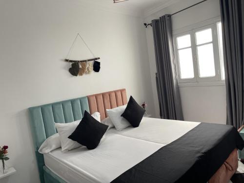 a bedroom with a bed with black and white pillows at Casa Marwan in Tetouan