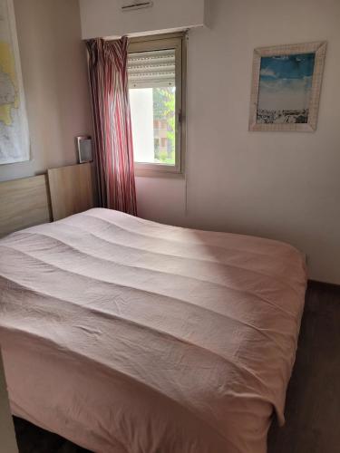 un grand lit dans une chambre avec une fenêtre dans l'établissement Appartement 2 chambres à 5 min à pieds de la plage et tout commerce, à Vallauris
