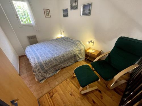 - une chambre avec un lit et une chaise verte dans l'établissement Charming loft with sea view, à Saint-Raphaël
