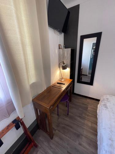 a desk in a room with a bed and a mirror at Hotel Clair Logis in Argelès-sur-Mer