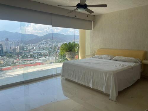 阿卡普尔科Brisa del Mar的一间卧室，里面有一张床和一扇大窗户。