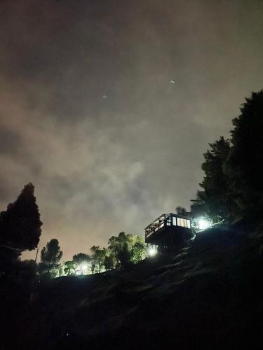 un train descend une colline la nuit dans l'établissement Cabañas Campestres con jacuzzi - San felix, à Medellín