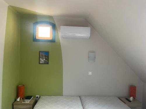 a small room with a bed and a window at Turul Panzió&Pizzéria in Szólád
