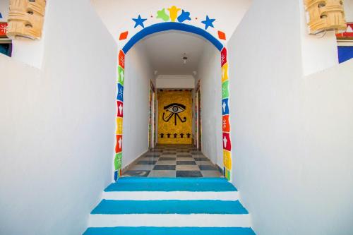 a hallway with blue and white stairs with a yellow door at Nubian Kulih house in Aswan