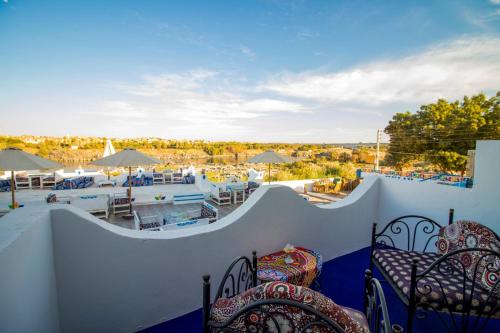 a balcony with chairs and a view of a pool at Nubian Kulih house in Aswan