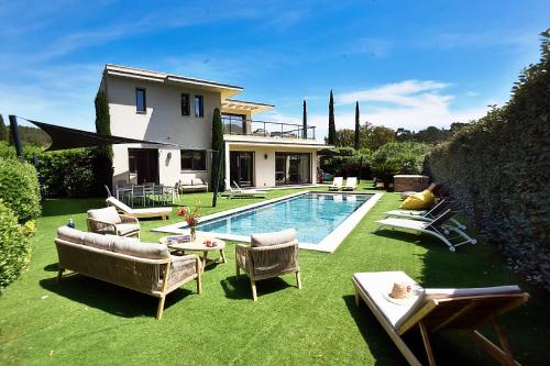 une arrière-cour avec une piscine, des chaises et une maison dans l'établissement Villa de luxe, piscine, plage 7mns, St Tropez 15km, à La Croix-Valmer