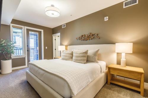 a bedroom with a large white bed and a window at Creekside Elegance at Timberstone in Canmore