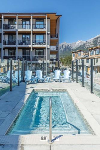 a swimming pool with chairs and a building at Creekside Elegance at Timberstone in Canmore