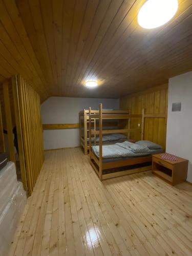 a room with two bunk beds and a wooden floor at Koča na Kranjski dolini Krnica 93 a,Pokljuka in Zgornje Gorje
