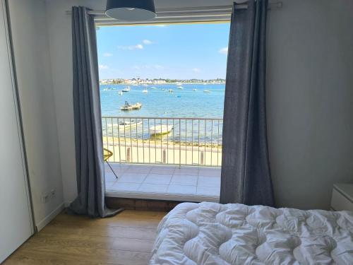 - une chambre avec une grande fenêtre donnant sur l'océan dans l'établissement Maison vue mer avec Jacuzzi, à Gâvres