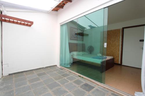 a glass room with a couch and a table at Wafeh Pampulha Suítes in Belo Horizonte