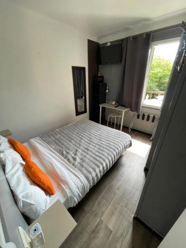a bedroom with a bed with an orange pillow on it at Hotel Clair Logis in Argelès-sur-Mer