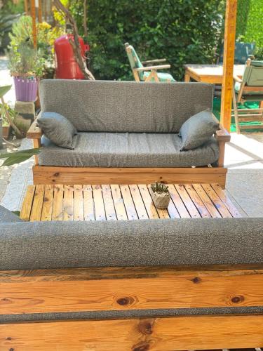 a couch sitting on top of a wooden deck at Rosemary Pansiyon in Cıralı