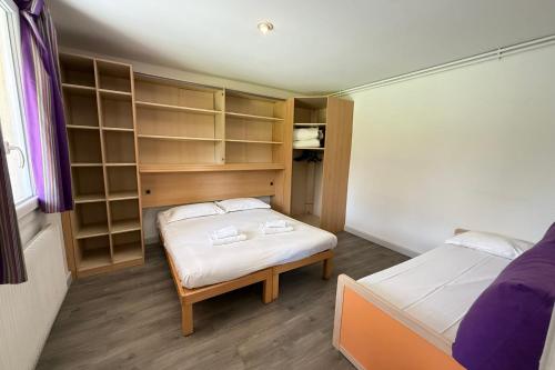 Cette petite chambre comprend 2 lits et des étagères. dans l'établissement Bright T3 cottage in secure domain, à La Roque-sur-Pernes