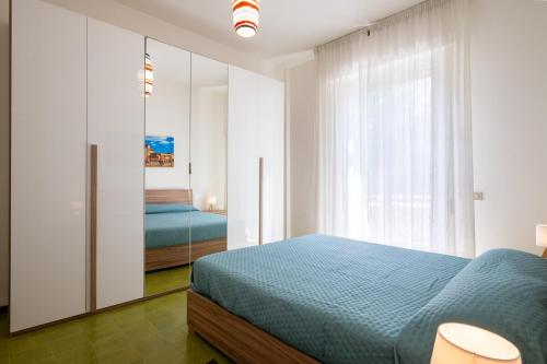 a bedroom with a blue bed and a mirror at La Casa del Sole-Viareggio in Viareggio
