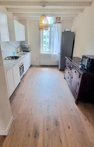 a kitchen with white cabinets and a wooden floor at ! Magnifique Appartement De Caractère a Metz ! in Montigny-lès-Metz