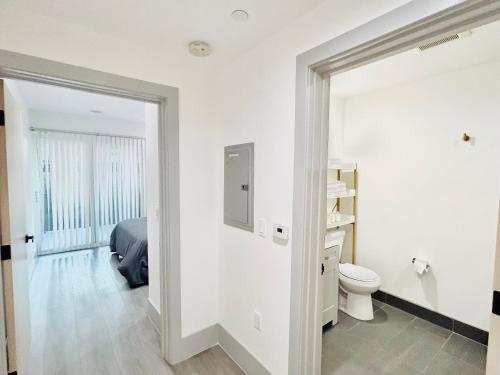 a white bathroom with a bed and a toilet at Newly Built Modern Central 2B On Sherman with Free Parking in North Sherman Way