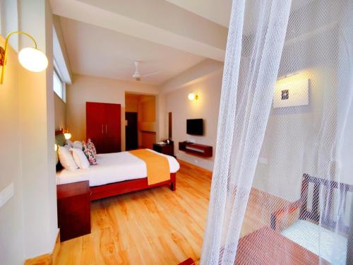 a hotel room with a bed and a tv at Dzongkar - MG Marg - 3 Star Hotel in Gangtok