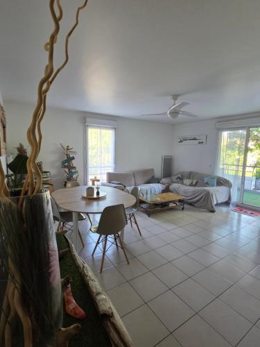 un salon avec une table et un canapé dans l'établissement Au pied des calanques, nature, plages à 6min, parking, bus direct, idéal famille, à Marseille
