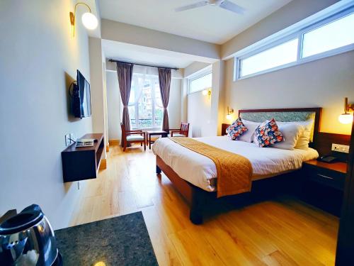 a bedroom with a large bed and a window at Dzongkar - MG Marg - 3 Star Hotel in Gangtok