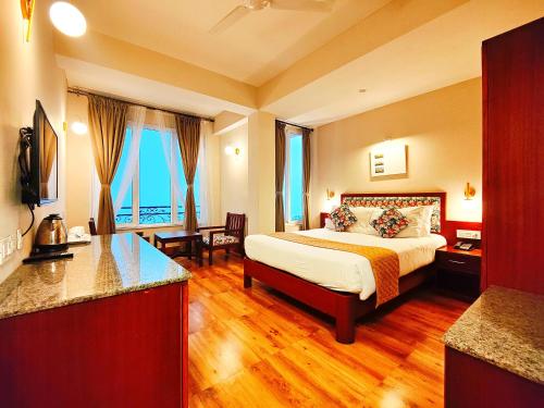 a hotel room with a bed and a kitchen at Dzongkar - MG Marg - 3 Star Hotel in Gangtok